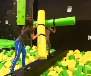 kids battling with foam on a balance beam