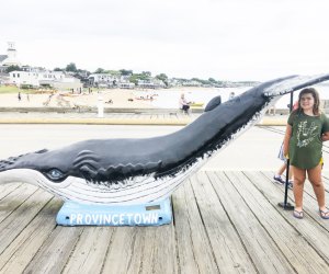 Photo of young woman with whale statue on Cape Cod.