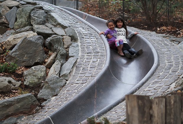 Smiling girls ride the slide at Billy Johnson Playground