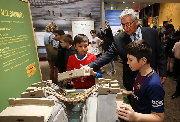Kevin Gover, the director of The National Museum of the American Indian, and visitors play with "Make It, Shake It" an interactive engineering bridge display. AP Images/Jason DeCrow for the museum