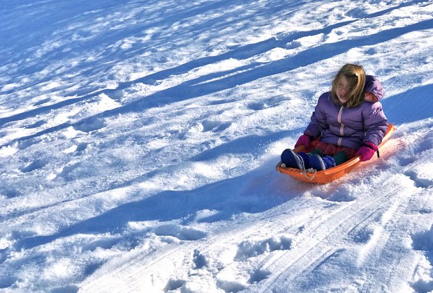 Best sledding hills in New Jersey: Little girl on a sled