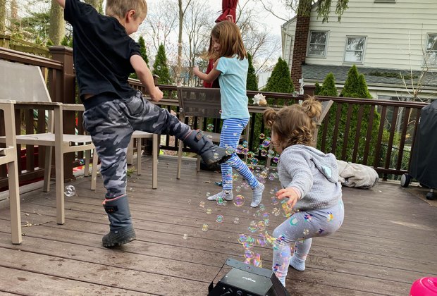 kids playing with bubbles on a deck